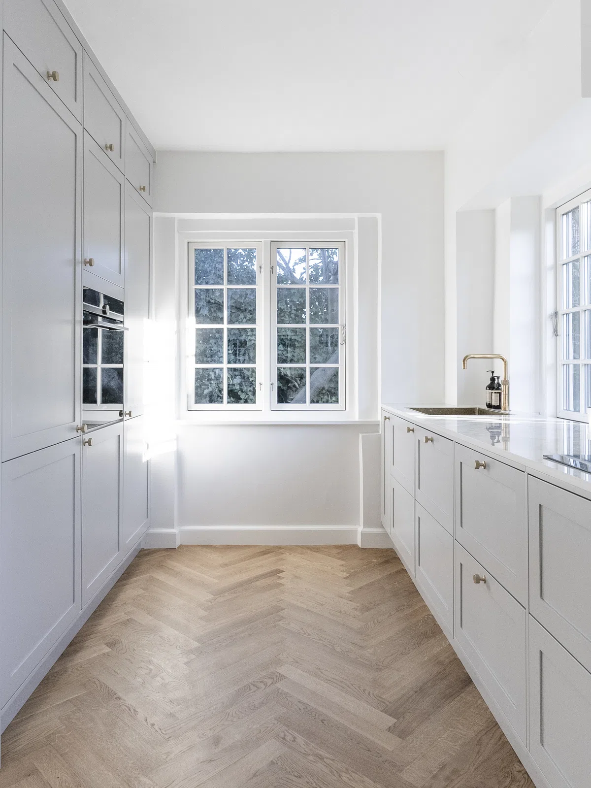 Lyst køkken med messingdetaljer fra Solheim Kitchen